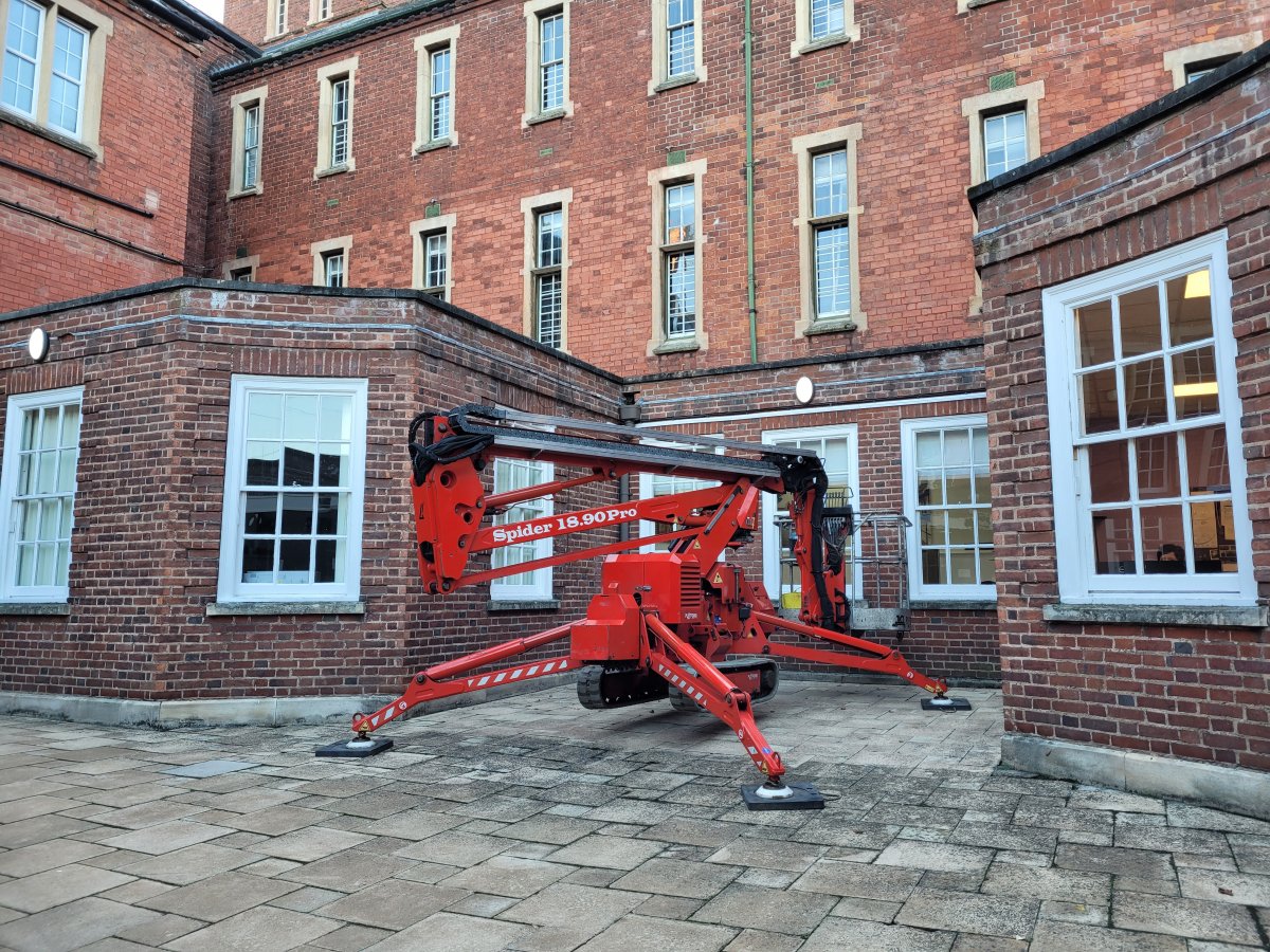 Photo shows tracked spider cherrypicker correctly and safely set up on paving slabs, ready to clear out guttering in LongEaton, Nottinghamshire