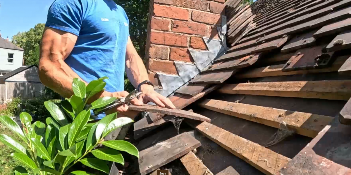 photo shows a roof being stripped of its clay tiles insearch for a roof leak next to a chimney in Mansfield, Nottinghamshire