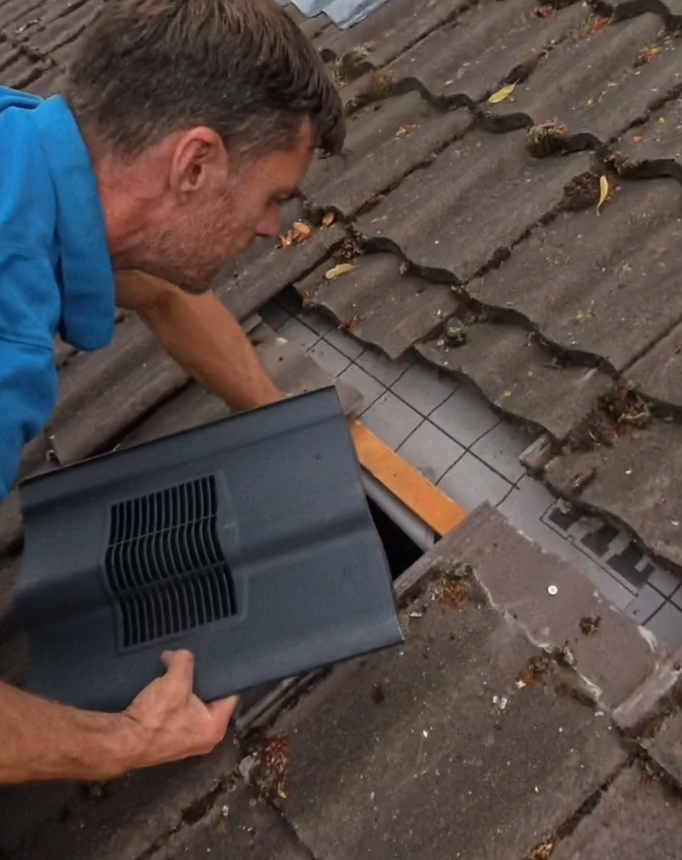 Danny Iwanejko is installing an air vent tile
