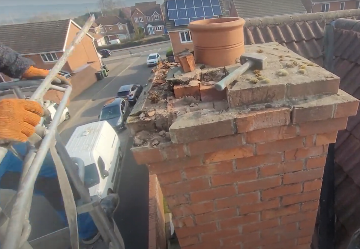 The bricks of a chimney are being removed by Dan the cherrypicker man, using a hammer and chisel. In Forest Town, Mansfield